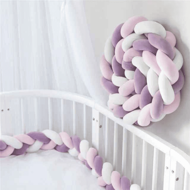 tresse-de-lit-violet-rose-blanc-placee-dans-un-berceau-blanc-lenidbebe