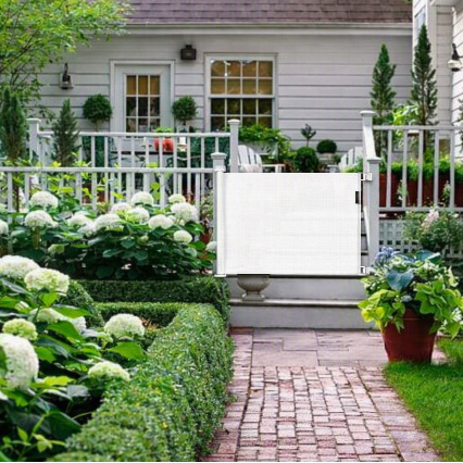 barriere-enfant-grille-retractable-blanche-installee-sur-terrasse-jardin-fleuri-ourson-veilleur