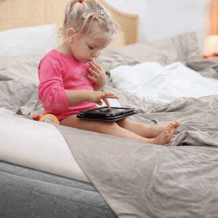 barriere-lit-enfant-fillette-assise-pres-boudin-blanc-bord-matelas-garde-douceur