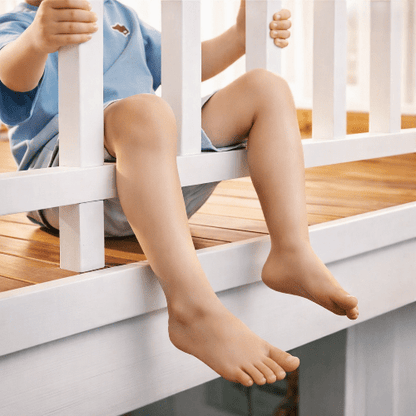 barriere-pour-enfant-garcon-assis-jambes-pendantes-entre-barreaux-bois-gardien-calme