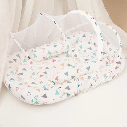 couffin-reducteur-de-lit-motif-triangles-multicolores-doux-moustiquaire-ouverte-ruisseau-tranquille