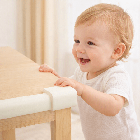 protecteur-de-coin-de-table-bebe-debout-main-table-souriant-babysafetycornerprotector-blanc