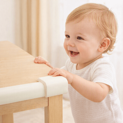 protecteur-de-coin-de-table-bebe-debout-main-table-souriant-babysafetycornerprotector-blanc