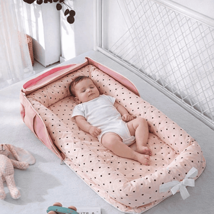 reducteur-de-lit-6-12-mois-bebe-endormi-dans-coussin-rose-nid-de-serenite