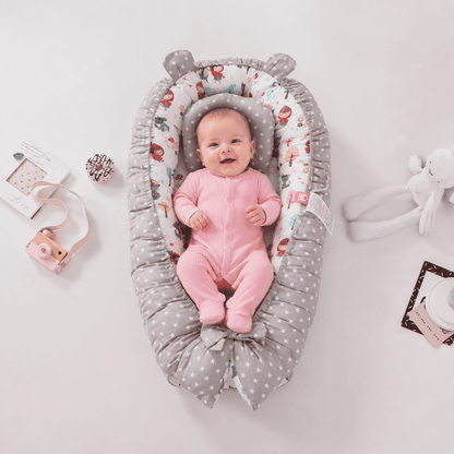 reducteur-de-lit-bebe-confort-rose-jouets-autour-nid-securisant-chambre-douce-sommeil-douceur