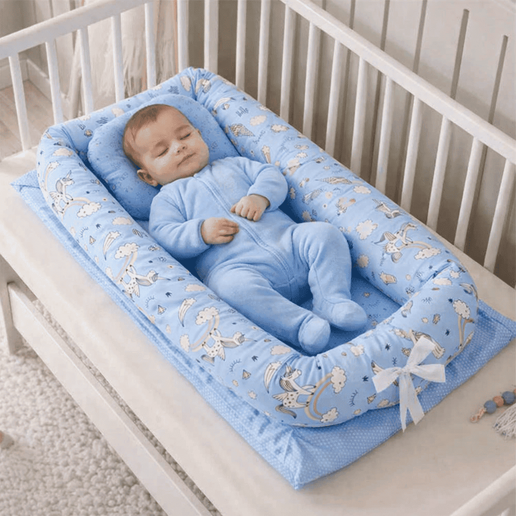 reducteur-de-lit-doomoo-bebe-allonge-dans-nid-bleu-imprime-confort-nursery-repos-calin