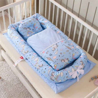 reducteur-de-lit-doomoo-devant-nid-bebe-bleu-motif-licornes-dans-berceau-repos-calin