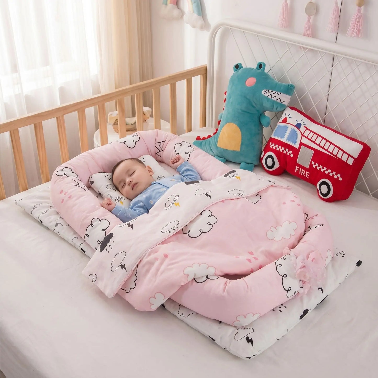 reducteur-de-lit-jollein-bebe-endormi-ambiance-rose-nuage-dinosaure-ecrin-de-serenite