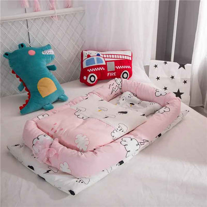 reducteur-de-lit-jollein-nid-bebe-rose-motif-nuages-sur-lit-enfant-douillet-ecrin-de-serenite