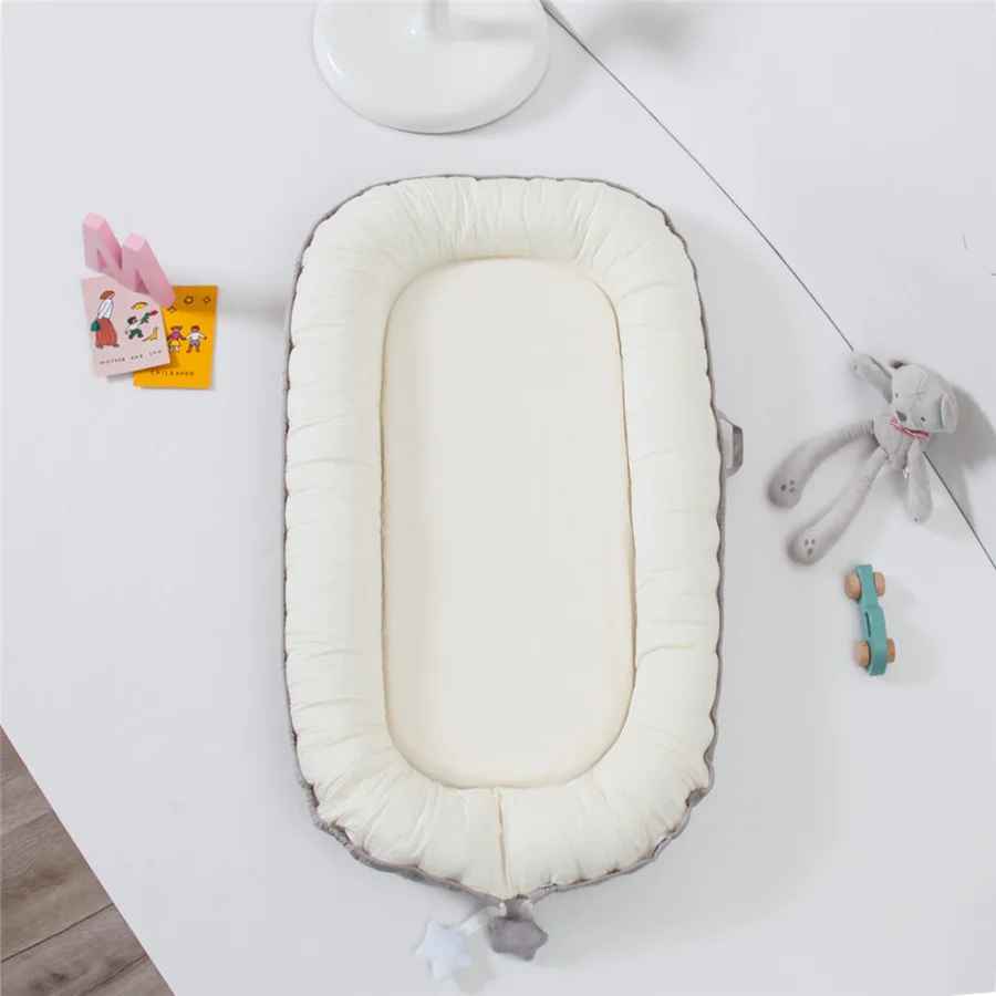reducteur-de-lit-nid-bebe-blanc-bord-gris-accessoires-enfant-livre-jouet-berceau-tranquille