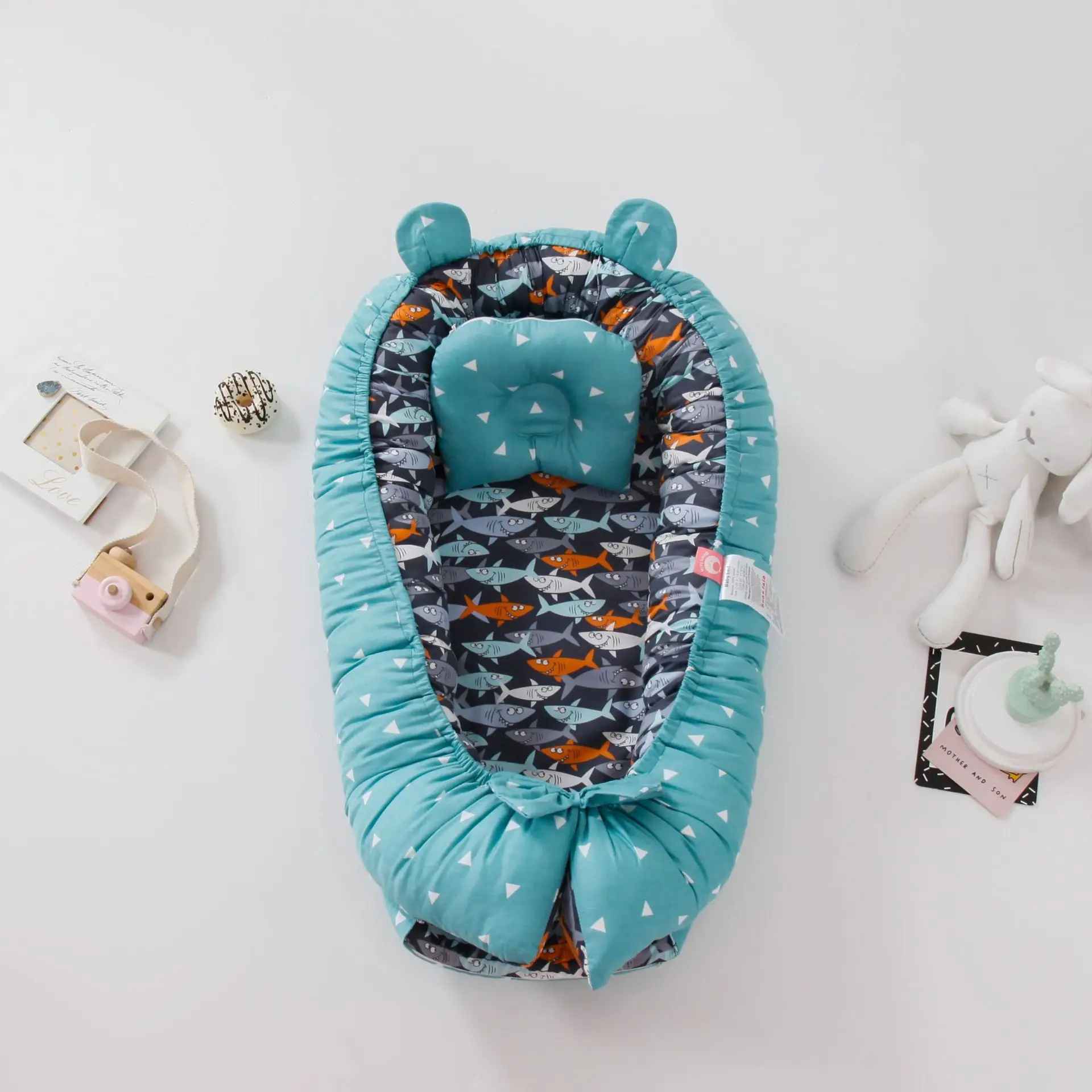 reducteur-de-lit-nid-bebe-turquoise-motif-requins-peluche-accessoires-chambre-enfant-reve-serenite