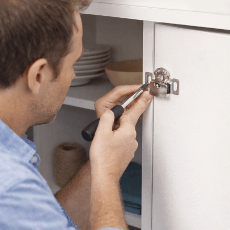 securite-placard-homme-installe-loquet-chrome-sur-armoire-blanche-tournevis-ouverture-tendre