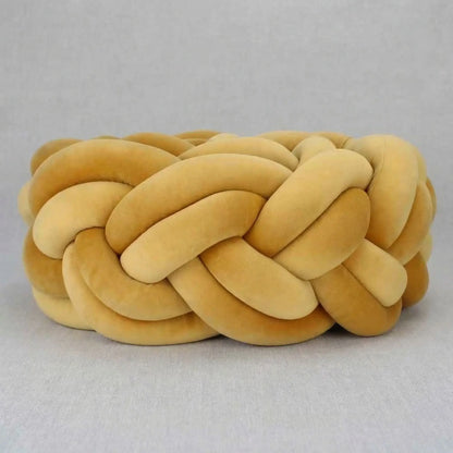 tresse-de-lit-bebe-coussin-tresse-rond-douillet-couleurs-chaudes-aube-caline