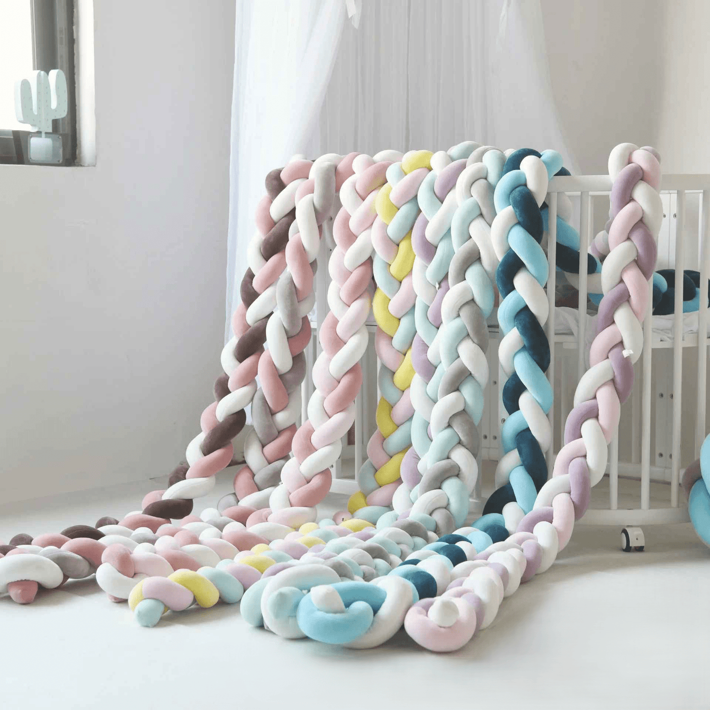 tresse-de-lit-collection-pastel-et-colorees-sur-berceau-blanc-decoration-nurserie-douce-et-securisee-pour-bebe-laperle