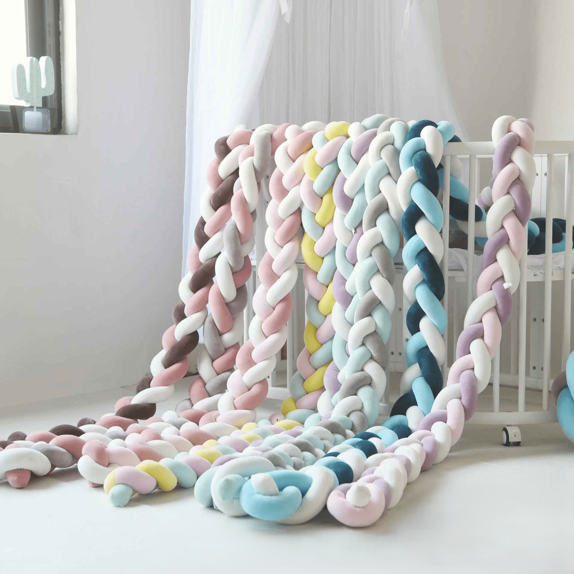 tresse-de-lit-collection-pastel-et-colorees-sur-berceau-blanc-decoration-nurserie-douce-et-securisee-pour-bebe-laperle