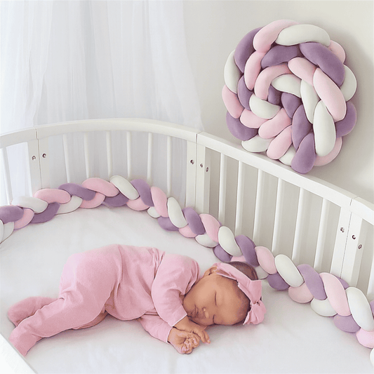 tresse-de-lit-violet-rose-blanc-placee-dans-un-berceau-blanc-bebe-endormi-habille-en-rose-lenidbebe