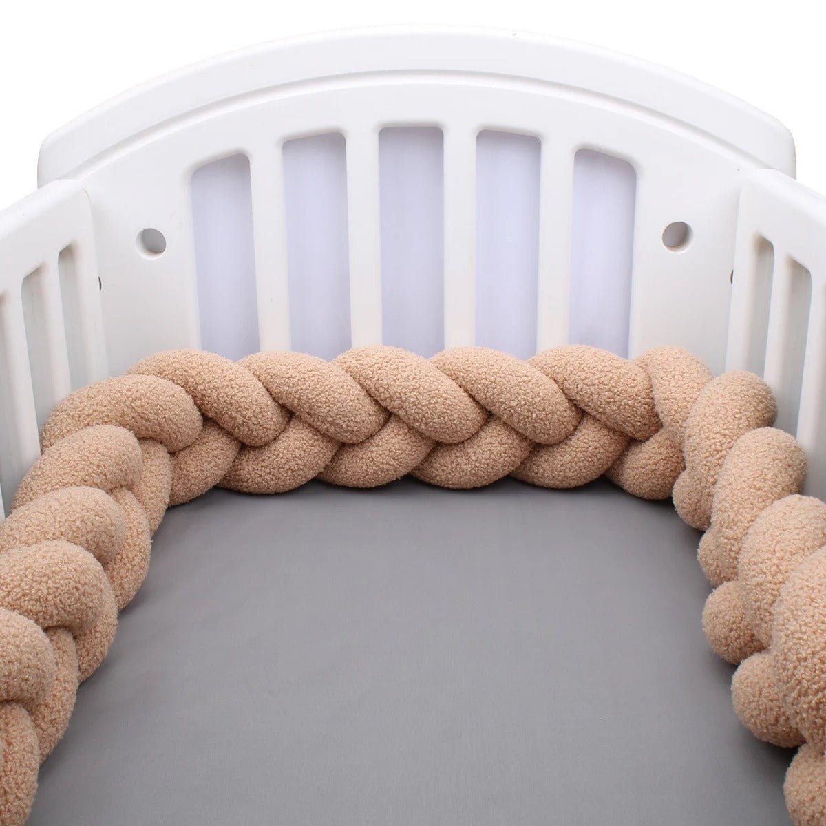 tresses-de-lit-bebe-beige-dans-lit-blanc-bim